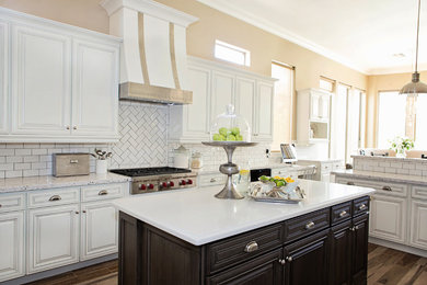 Example of a transitional ceramic tile eat-in kitchen design in Phoenix with dark wood cabinets, white backsplash, subway tile backsplash, stainless steel appliances and an island