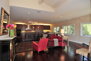 Example of a mid-sized trendy galley dark wood floor open concept kitchen design in San Francisco with a single-bowl sink, recessed-panel cabinets, dark wood cabinets, granite countertops, beige backsplash, stone tile backsplash and paneled appliances