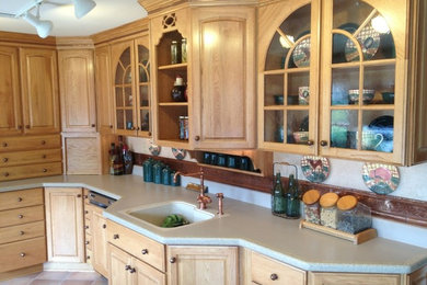 Enclosed kitchen - mid-sized traditional u-shaped light wood floor enclosed kitchen idea in Philadelphia with a drop-in sink, raised-panel cabinets, light wood cabinets and laminate countertops