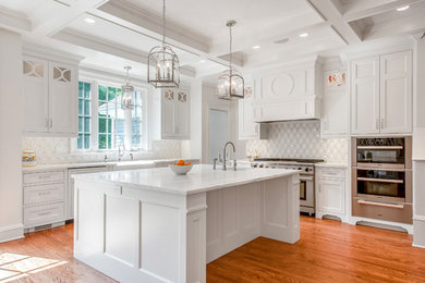 Eat-in kitchen - large traditional l-shaped light wood floor eat-in kitchen idea in New York with a farmhouse sink, beaded inset cabinets, white cabinets, marble countertops, white backsplash, ceramic backsplash, paneled appliances and an island