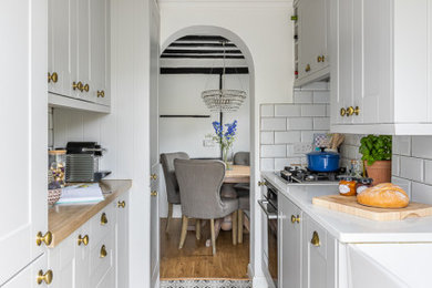 Design ideas for a farmhouse enclosed kitchen in Buckinghamshire with shaker cabinets, quartz worktops, ceramic splashback and ceramic flooring.