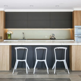 Inspiration for a large contemporary galley open plan kitchen in Sydney with a drop-in sink, flat-panel cabinets, quartz benchtops, porcelain floors, with island, white benchtop, grey cabinets, glass sheet splashback, white appliances and grey floor.