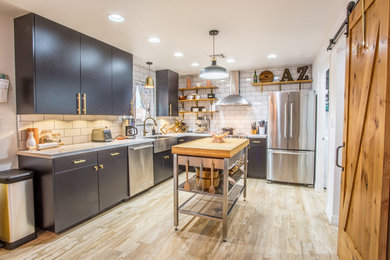 Example of an urban kitchen design in Phoenix with a farmhouse sink, white backsplash, stainless steel appliances and an island