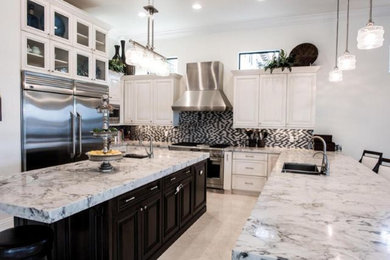 Open concept kitchen - mid-sized modern u-shaped limestone floor and beige floor open concept kitchen idea in Miami with an undermount sink, raised-panel cabinets, marble countertops, multicolored backsplash, glass tile backsplash, stainless steel appliances, white cabinets and an island