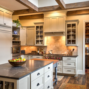 Ispirazione per una cucina country con top in saponaria, 2 o più isole, ante in stile shaker, ante bianche, paraspruzzi beige, elettrodomestici in acciaio inossidabile, parquet scuro, lavello sottopiano e paraspruzzi in pietra calcarea
