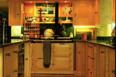 Photo of a large farmhouse kitchen/diner in Cornwall with a double-bowl sink, shaker cabinets, green splashback, medium hardwood flooring and an island.