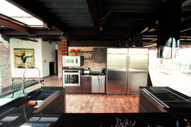Diseño de cocina comedor industrial con armarios con paneles lisos y una isla