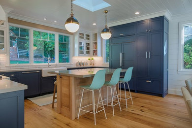 Eat-in kitchen - mid-sized cottage u-shaped light wood floor and beige floor eat-in kitchen idea in San Francisco with a farmhouse sink, recessed-panel cabinets, blue cabinets, quartz countertops, white backsplash, subway tile backsplash, colored appliances, an island and beige countertops