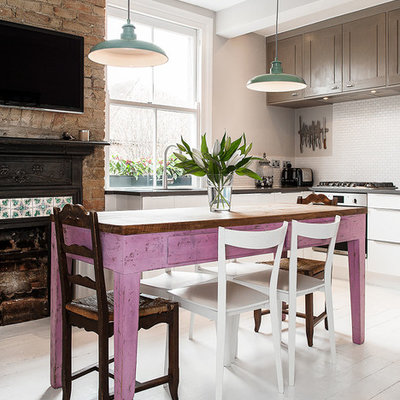 Inspiration for a mid-sized country l-shaped painted wood floor enclosed kitchen remodel in London with an undermount sink, shaker cabinets, granite countertops, white backsplash, mosaic tile backsplash and stainless steel appliances