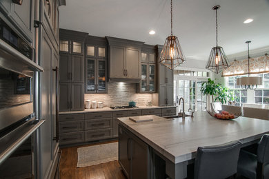 Example of a large transitional single-wall light wood floor and brown floor eat-in kitchen design in Charlotte with a single-bowl sink, recessed-panel cabinets, gray cabinets, limestone countertops, multicolored backsplash, marble backsplash, stainless steel appliances, an island and multicolored countertops