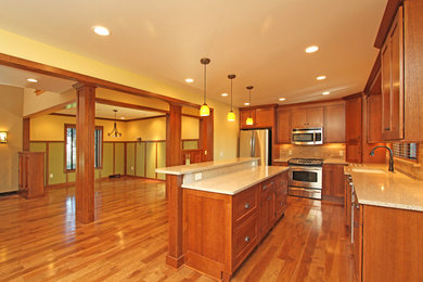 Inspiration for a large craftsman l-shaped medium tone wood floor eat-in kitchen remodel in Other with an undermount sink, shaker cabinets, medium tone wood cabinets, quartz countertops, multicolored backsplash, stone tile backsplash, stainless steel appliances and an island
