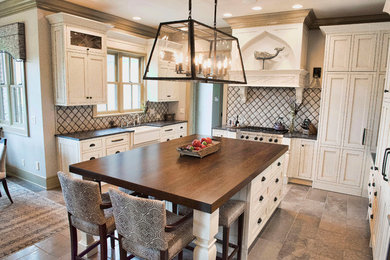 Diseño de cocina clásica renovada con fregadero sobremueble, armarios con paneles empotrados, electrodomésticos de acero inoxidable y suelo de baldosas de cerámica