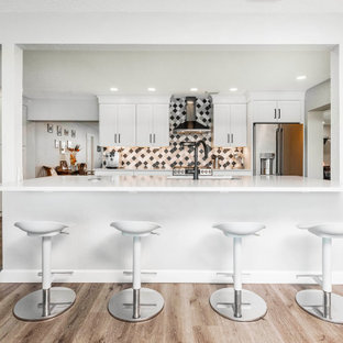Large transitional kitchen pantry ideas - Example of a large transitional vinyl floor and brown floor kitchen pantry design in Orlando with an undermount sink, shaker cabinets, white cabinets, quartzite countertops, multicolored backsplash, porcelain backsplash, stainless steel appliances, an island and white countertops