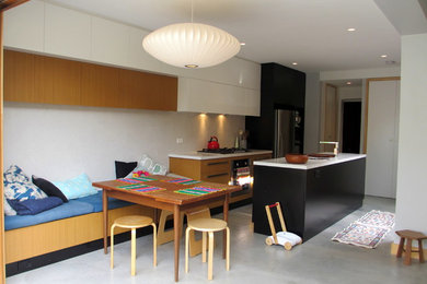 Foto de cocina comedor lineal moderna con salpicadero blanco, electrodomésticos de acero inoxidable, suelo de cemento y una isla