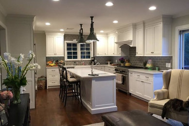 Foto de cocina tradicional renovada de tamaño medio con salpicadero verde, electrodomésticos de acero inoxidable y una isla