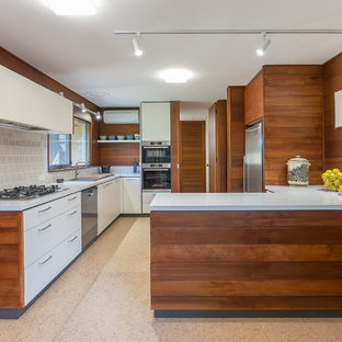 Inspiration for a mid-sized contemporary u-shaped kitchen in Melbourne with quartz benchtops, beige splashback, ceramic splashback, stainless steel appliances, cork floors, beige floor, white benchtop, flat-panel cabinets, white cabinets and a peninsula.