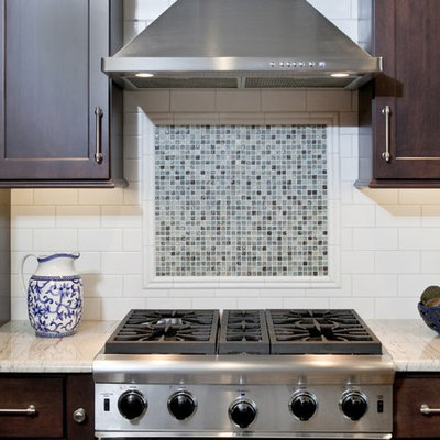 Eat-in kitchen - large transitional l-shaped medium tone wood floor eat-in kitchen idea in Philadelphia with a single-bowl sink, shaker cabinets, dark wood cabinets, granite countertops, white backsplash and an island