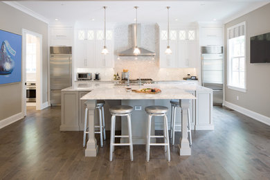 Large transitional medium tone wood floor eat-in kitchen photo in Philadelphia with two islands, recessed-panel cabinets, gray cabinets, marble countertops, gray backsplash, mosaic tile backsplash, stainless steel appliances and an integrated sink