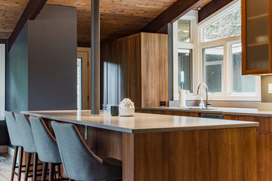 Immagine di una cucina moderna di medie dimensioni con lavello a doppia vasca, ante lisce, ante in legno scuro, top in granito, paraspruzzi beige, elettrodomestici in acciaio inossidabile, parquet chiaro, pavimento beige e top beige
