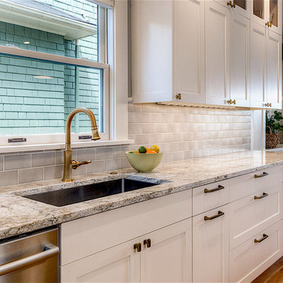 Example of a mid-sized classic u-shaped dark wood floor and brown floor eat-in kitchen design in Seattle with an undermount sink, recessed-panel cabinets, white cabinets, marble countertops, gray backsplash, subway tile backsplash, stainless steel appliances, an island and gray countertops