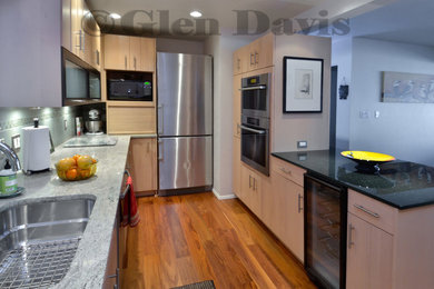 Photo of a medium sized contemporary galley kitchen/diner in Seattle with a submerged sink, flat-panel cabinets, light wood cabinets, marble worktops, multi-coloured splashback, mosaic tiled splashback, stainless steel appliances, bamboo flooring and no island.