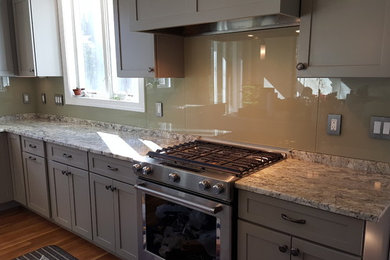 Esempio di una cucina minimal di medie dimensioni con ante con riquadro incassato, ante grigie, top in granito, paraspruzzi grigio e paraspruzzi con lastra di vetro