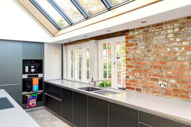 Offene, Große Moderne Küche in L-Form mit flächenbündigen Schrankfronten, grauen Schränken, Quarzwerkstein-Arbeitsplatte und Kücheninsel in Hampshire