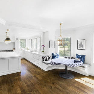 Inspiration for a timeless l-shaped dark wood floor and brown floor eat-in kitchen remodel in Boston with an undermount sink, shaker cabinets, white cabinets, white backsplash and an island