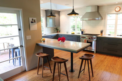 Eat-in kitchen - large modern u-shaped medium tone wood floor and brown floor eat-in kitchen idea in San Francisco with an undermount sink, shaker cabinets, blue cabinets, quartz countertops, white backsplash, subway tile backsplash, stainless steel appliances, a peninsula and beige countertops