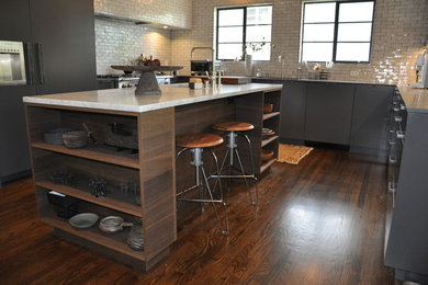 Eat-in kitchen - mid-sized modern u-shaped dark wood floor and brown floor eat-in kitchen idea in San Francisco with flat-panel cabinets, gray cabinets, an island, an undermount sink, marble countertops, white backsplash, subway tile backsplash and stainless steel appliances