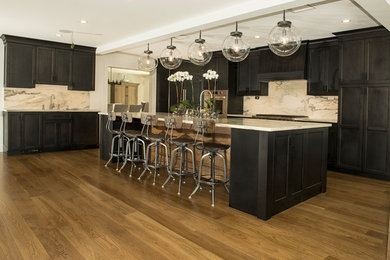 Inspiration for a large craftsman medium tone wood floor and brown floor open concept kitchen remodel in New York with a farmhouse sink, shaker cabinets, brown cabinets, gray backsplash, stone slab backsplash, stainless steel appliances and an island
