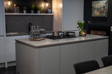 This is an example of a kitchen in Other with grey cabinets, quartz worktops, an island and grey worktops.