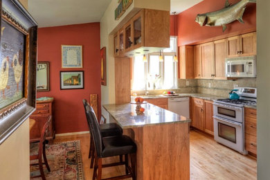 Mid-sized transitional u-shaped light wood floor eat-in kitchen photo in Baltimore with an undermount sink, shaker cabinets, medium tone wood cabinets, granite countertops, beige backsplash, ceramic backsplash, white appliances and a peninsula