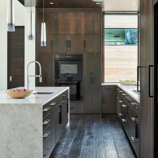 Design ideas for a mid-sized modern u-shaped open plan kitchen in Denver with an undermount sink, flat-panel cabinets, dark wood cabinets, dark hardwood floors, with island, brown floor, limestone benchtops, panelled appliances and white benchtop.