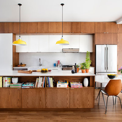 Eat-in kitchen - 1950s single-wall eat-in kitchen idea in Toronto with a farmhouse sink, flat-panel cabinets, medium tone wood cabinets, white backsplash, mosaic tile backsplash, stainless steel appliances and an island