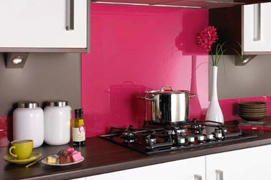 Идея дизайна: кухня в современном стиле с розовым фартуком и фартуком из стекла