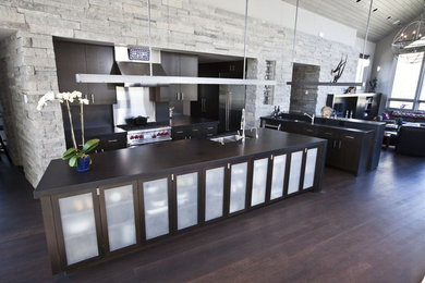 デンバーにある広いコンテンポラリースタイルのおしゃれなキッチン (フラットパネル扉のキャビネット、濃色木目調キャビネット) の写真