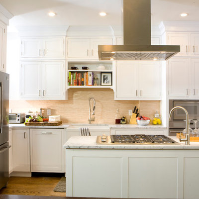 Inspiration for a timeless u-shaped kitchen remodel in New York with stainless steel appliances, a farmhouse sink, shaker cabinets, white cabinets, marble countertops and beige backsplash