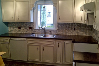 This is an example of a contemporary kitchen in Other with white cabinets and an island.