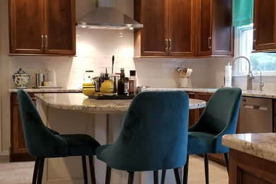 Mid-sized transitional l-shaped porcelain tile and beige floor enclosed kitchen photo in Philadelphia with an undermount sink, recessed-panel cabinets, medium tone wood cabinets, granite countertops, white backsplash, subway tile backsplash, stainless steel appliances, an island and multicolored countertops