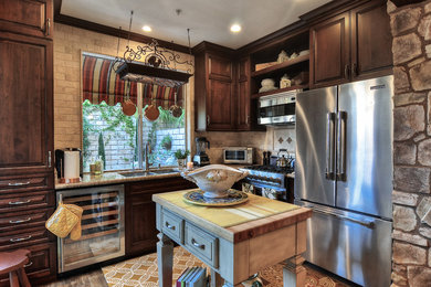 Example of a small classic l-shaped kitchen design in Orange County with a double-bowl sink, raised-panel cabinets, dark wood cabinets and an island