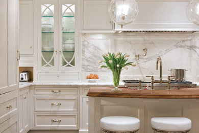 Elegant kitchen photo in Chicago with glass-front cabinets, marble countertops, white backsplash, an island, white cabinets and marble backsplash