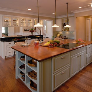 Photo of a tropical open plan kitchen in Hawaii with raised-panel cabinets, wood benchtops and green cabinets.