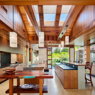 Expansive tropical galley separate kitchen in Hawaii with a double-bowl sink, flat-panel cabinets, medium wood cabinets, wood benchtops, stainless steel appliances and multiple islands.