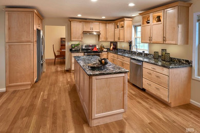 Inspiration for a transitional kitchen remodel in Indianapolis with recessed-panel cabinets, light wood cabinets, stainless steel appliances and an island