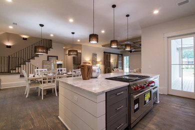 Large transitional l-shaped dark wood floor eat-in kitchen photo in Atlanta with a farmhouse sink, recessed-panel cabinets, gray cabinets, marble countertops, gray backsplash, stone tile backsplash, stainless steel appliances and an island