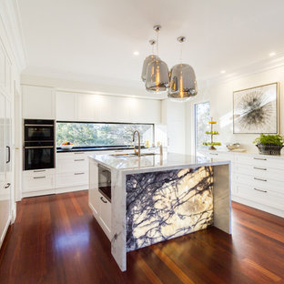 Inspiration for a large contemporary u-shaped eat-in kitchen in Melbourne with an undermount sink, white cabinets, marble benchtops, window splashback, dark hardwood floors, with island, brown floor, white benchtop, recessed-panel cabinets and stainless steel appliances.