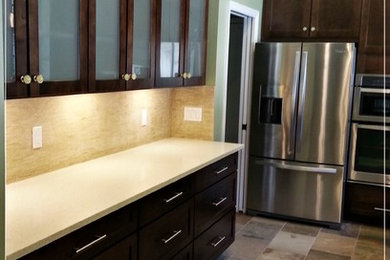 Example of a trendy u-shaped slate floor kitchen design in Miami with shaker cabinets, dark wood cabinets, quartz countertops, beige backsplash and stainless steel appliances