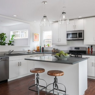 Transitional l-shaped dark wood floor kitchen photo in San Francisco with an undermount sink, shaker cabinets, white cabinets, stainless steel appliances and an island
