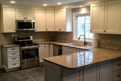 Example of a kitchen design in Philadelphia with white cabinets and granite countertops